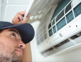 Man Inspecting Air Conditioning Unit