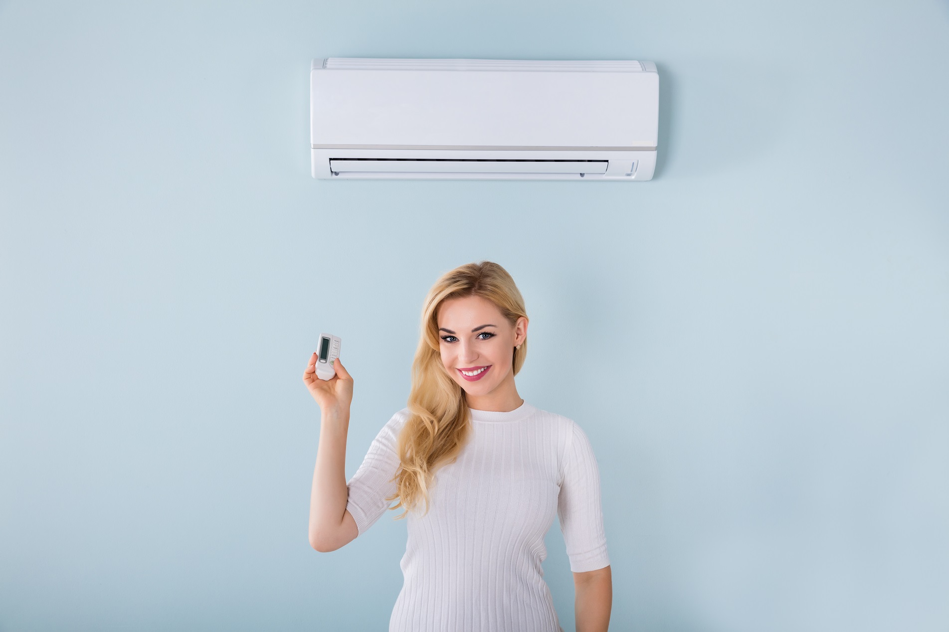 Woman Holding Remote Controller Of Air Conditioner